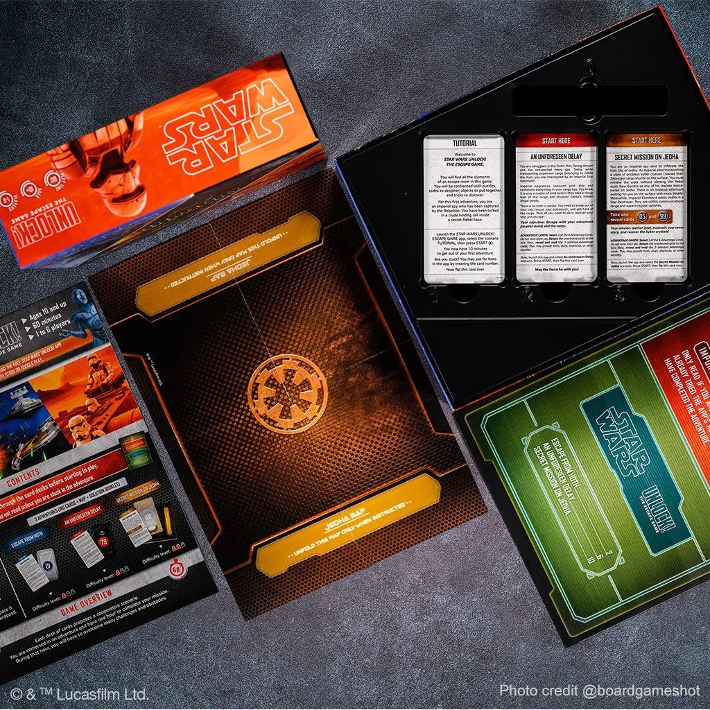 Board game components including cards, rulebook, and tokens in a box.