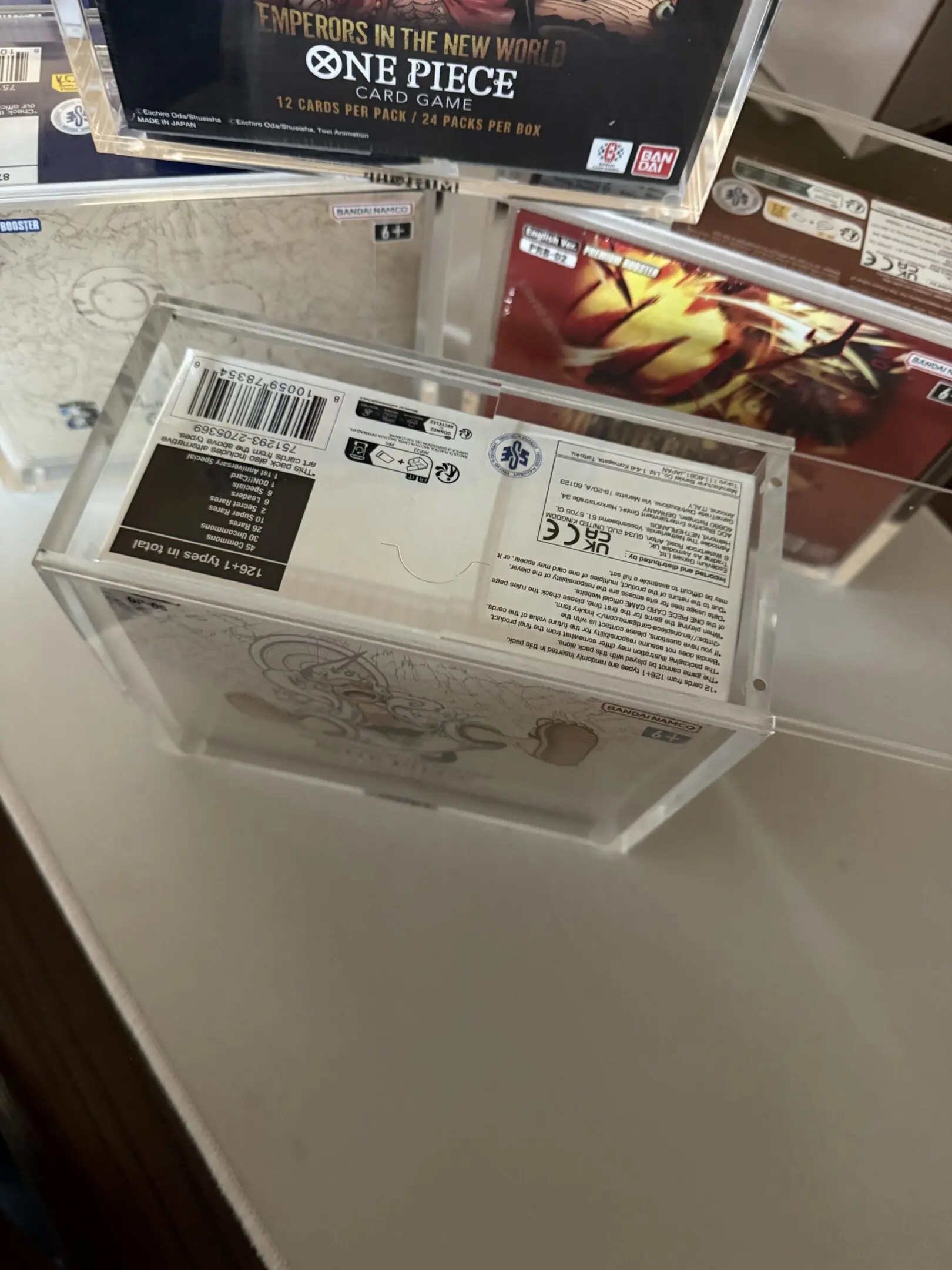 A clear protective box holding a sealed tech gadget box on a table.
